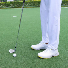 Golfer wearing Sampson Men's Golf Shoes preparing to putt on the green.