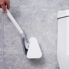 Modern silicone toilet brush in holder, shown next to a toilet on a marble floor for efficient cleaning and stylish bathroom organization.